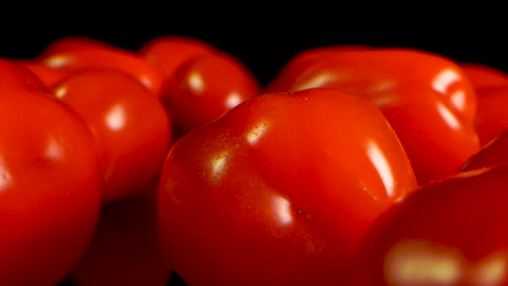 Extreme-Close-Up-slide-on-red-Cherry-Tomatoes-on-a-black-table