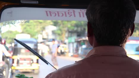Closeup-Shoulder-Shot-Of-Auto-Rikshaw-Driver-Driving-On-Busy-Road