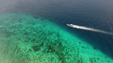 Indonesian-boat-sailing-over-a-coral-reef-in-Gili-Trawangan,-beautiful-shot-tracking-small-tourist-boat
