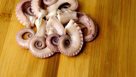 High-angle-shot-of-an-arrangement-of-Octopus-tentacles-rotating-on-a-wooden-surface