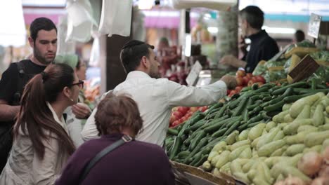 Mahane-Yehuda-market-in-Jerusalem,-man-Buy-Cucumbers