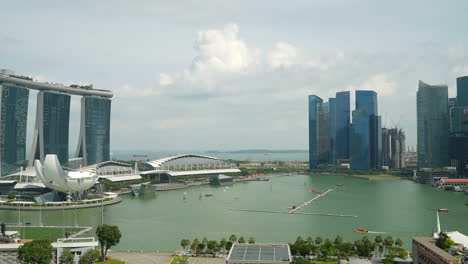 Singapur-–-Ca.-Zeitraffer-über-Singapurs-Bay-Marina-Mit-Dem-Berühmten-Marina-Bay-Sands-Hotel-Und-Gruppen-Von-Segelbooten,-Die-Durch-Die-Bucht-Segeln
