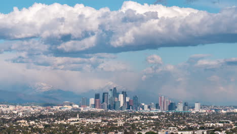 Time-lapse-of-storm-clouds-racing-over-downtown-Los-Angeles-with-snow-capped-mountains-in-background