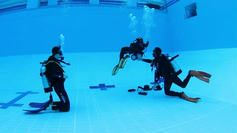 A-male-instructor-training-to-Asian-females-to-learn-how-to-scuba-dive
