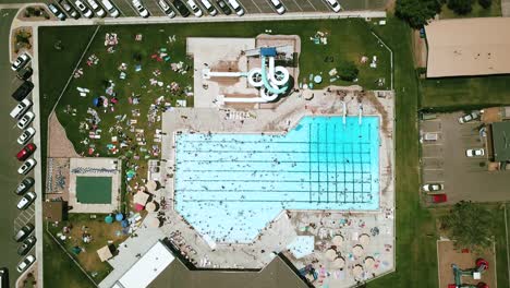 Lowering-drone-shot-directly-above-an-outdoor-public-pool