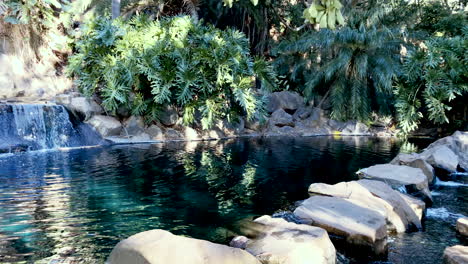 Zeitlupenschwenk-Eines-Steinweges-Mit-Fließendem-Wasserfall-Und-Friedlichem-Teich,-Toowoomba,-Queensland