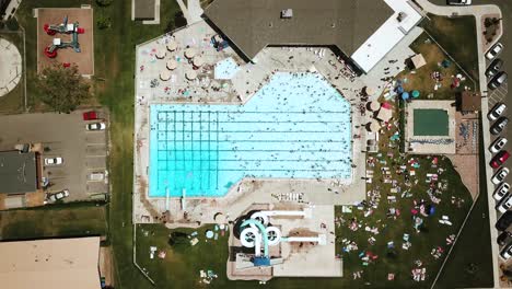 Lowering-drone-shot-directly-above-an-outdoor-public-pool