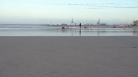 A-slider-low-depth-of-field-shot-of-a-man-walking-at-the-beach