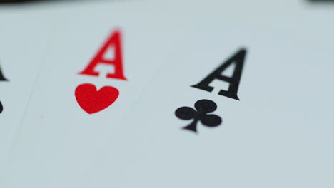 Macro-detail-shot-of-top-of-playing-cards-with-all-four-aces-hearths-diamonds-space-cross-lying-on-an-elephant-while-moving-as-the-cards-slowly-expose-from-the-side