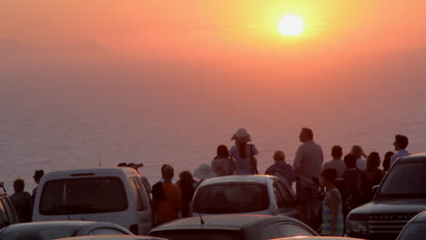 Santorini-sunset-from-a-parking-lot-with-people-watching