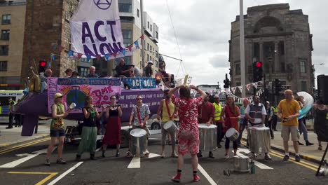 Extinction-Rebellion-protesters-playing-music-in-front-of-a-purple-boat-that-is-blocking-off-one-of-the-main-roads-in-Glasgow-city-centre