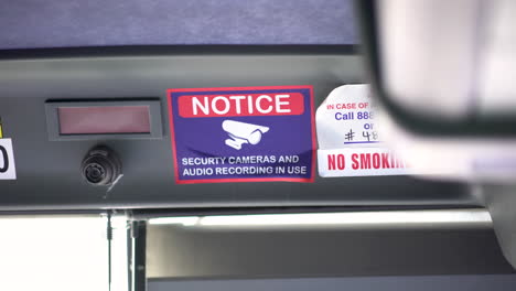Quick-4k-glimpse-at-a-generic-security-camera-warning-sign-on-a-public-bus-in-California