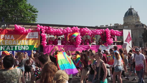 Ein-Mit-Rosa-Luftballons-Und-Der-Regenbogenfahne-Bedeckter-Lastwagen-Bahnt-Sich-Langsam-Seinen-Weg-Durch-Die-Menschen,-Die-Beim-Gay-Pride-In-Paris,-Frankreich,-Marschieren
