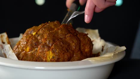 Man-Chef-slicing-a-whole-roasted-and-spiced-cauliflower