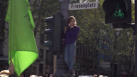 Young-girl-watches-international-"Fridays-for-Future"-strikers-protesting-for-more-climate-justice-in-Cologne,-Germany