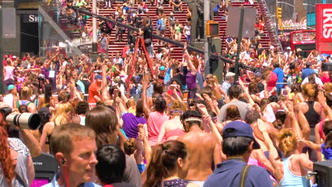 Zoom-out,-Thousands-of-people-exercise-yoga-on-Times-Square,-Manhattan