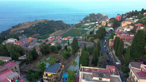 Aerial-view-of-green-hills-carpeted-with-buildings-and-the-Mediterranean-sea-in-the-background