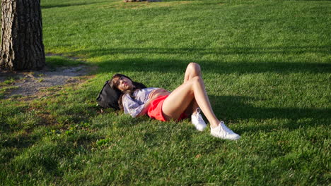 Beautiful-young-hispanic-woman-in-a-daydream-in-a-grass-public-park-field-watching-the-clouds