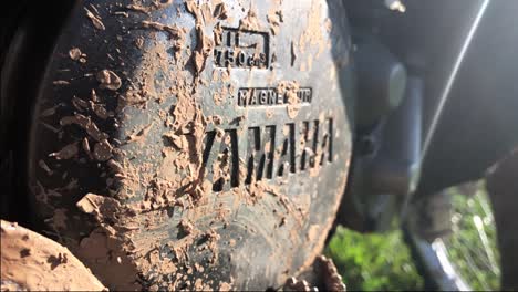 Engraved-logotype-of-Yamaha-on-motocross-bike-machine-covered-with-dirt-in-slow-motion-on-a-sunny-day-in-summer
