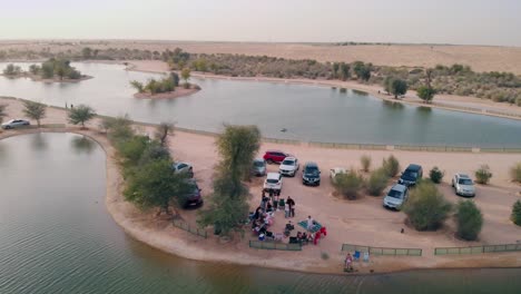 Luftaufnahme-Einer-Drohne-Von-Freunden,-Die-In-Der-Nähe-Der-Al-Qudra-Seen-In-Der-Wüste-Von-Dubai,-Vereinigte-Arabische-Emirate,-Ein-Picknick-Machen