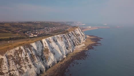 Drone-flies-along-the-sunny-White-Cliffs-of-Dover-with-beautiful-landscape-in-the-background-and-turquoise-sea-in-the-foreground