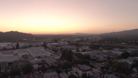 Rising-aerial-over-Glendale,-California-overlooking-suburban-area-and-highway-134-during-sunset