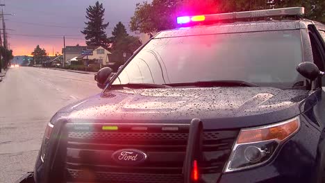 Police-car-at-dusk-after-a-rain-storm-with-it's-light-on