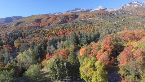 A-drone-flies-over-the-rocks-and-slopes-of-Dry-Creek-Trailhead-in-Alpine,-Utah-as-leaves-change-into-brilliant-fall-colors