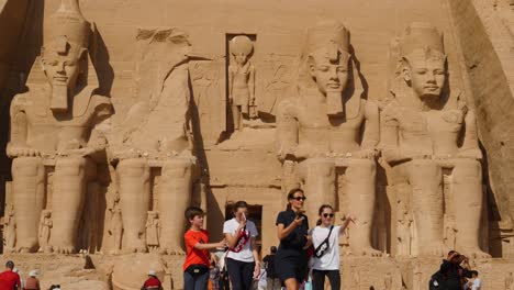 Hot-tourists-walk-away-from-the-famous-Abu-Simbel-Temple-and-giant-statues-of-King-Ramses-II-in-Egypt