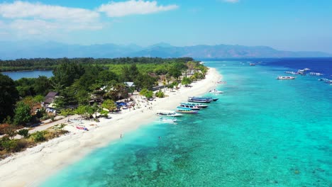 Playa-Blanca-De-Isla-Tropical-Bañada-Por-Una-Laguna-Turquesa-Llena-De-Botes-Turísticos-Esperando-A-Que-Los-Turistas-Suban-A-Bordo-Comenzando-El-Viaje-Alrededor-De-Las-Islas-En-Bali