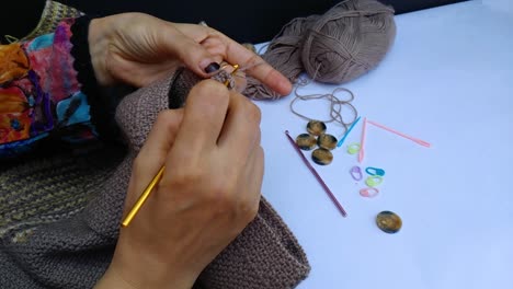 close-up-shot-of-professional-woman-hands-crocheting-woolen-sweater-in-high-speed-movement
