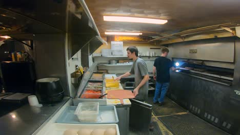 Kitchen-staff-making-pizzas-the-kitchen-in-a-family-owned-pizzeria-restaurant