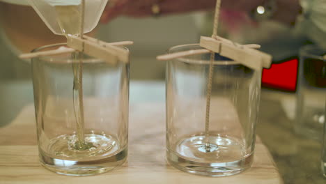 Nahaufnahme-Von-Heißem-Wachs,-Das-In-Zeitlupe-In-Ein-Leeres-Kerzenglas-Neben-Einem-Leeren-Glas-Gießt