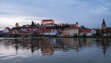 Zeitraffer-Eines-Sonnenuntergangs-über-Der-Stadt-Ptuj-Mit-Dem-Fluss-Undernett-In-Slowenien