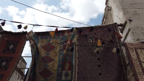 Originals-Turkish-carpets-hanged-outside-a-store-slowly-moving-due-to-some-wind
