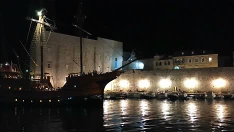 Night-footage-of-wooden-galleon-entering-port-in-Dubrovnik,-Croatia