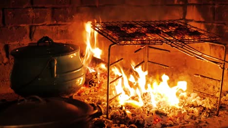 Lamb's-livers-wrapped-in-netvet-being-barbecued-on-open-fire-with-red-hot-coals,-fat-dripping,-South-African-tradition
