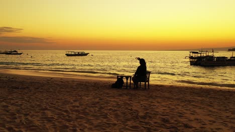Insel-Boracay,-Philippinen-–-Tourist-Sitzt-Auf-Dem-Stuhl-Und-Genießt-Das-Fotografieren-Mit-Wunderschönem-Orangefarbenen-Sonnenuntergang-Und-Segelbooten-Im-Hintergrund-–-Weitwinkelaufnahme