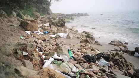 Plastic-disaster,-Full-of-plastic-wastes-in-a-foggy-sand-beach