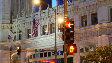 Chicago,-Michigan-Avenue-view,-street-corner,-trafic-red-light,-Usa,-United-States,-American-flag-waving,-modern-architecture,-by-night