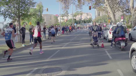 Fans-watch-marathon-contestants-running-down-road,-Zurich-Marathon-Malaga