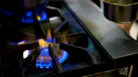 Chef-taking-a-pot-off-a-gas-burner-in-a-commercial-kitchen