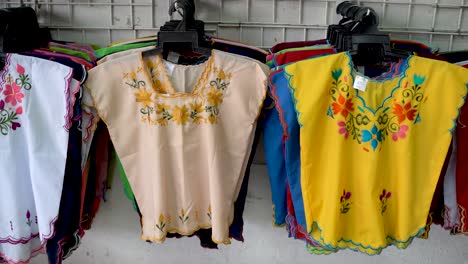 Camera-moving-to-right-and-panning-left-showing-colorful-designer-huipil-blouses-indigenous-to-Merida,-Yucatan,-Mexico