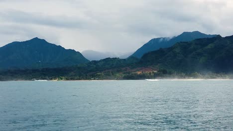 HD-120fps-Hawaii-Kauai-Boating-on-the-Ocean-floating-right-to-left-with-mountain-and-green-hills-in-distance-with-boat-spray-in-foreground
