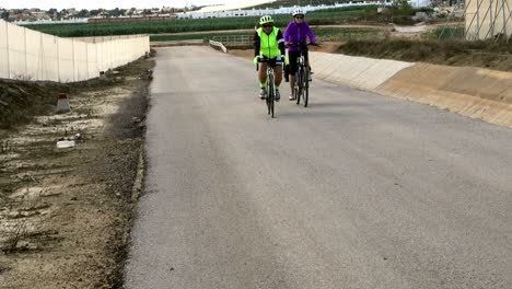 Cyclist-taking-daily-exercise-along-road-running-next-to-aqueduct-in-Spain