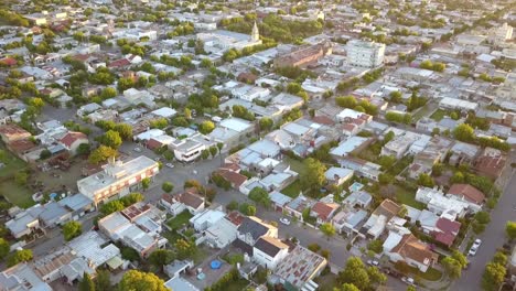 Aerial-Drone-shot-tilting-up-of-a-little-town-during-sunset,-in-Coronel-Dorrego,-Argentina