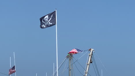 Eine-Piratenflagge-Wehte-Von-Einem-Fahnenmast-Vor-Blauem-Himmel