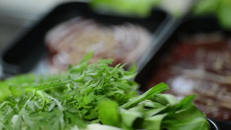 Preparing-a-delicious-soup-with-meat-and-green-leafy-ingredients---closeup-shot