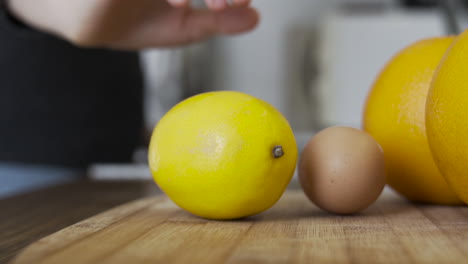 Slow-motion-as-taking,-picking-up-a-lemon-in-the-kitchen