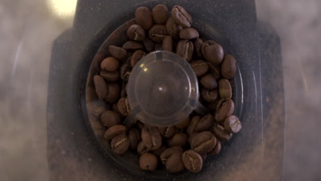 Coffee-beans-being-dropped-into-burr-grinder-in-slow-motion